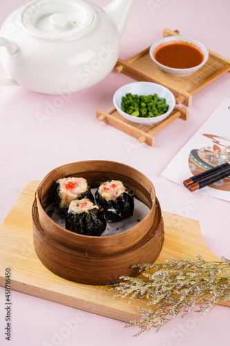 Assorted Chinese Dimsum in bamboo basket. Dimsum is a large range of small dishes that Cantonese people traditionally enjoy in restaurants for breakfast and lunch.