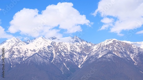 picturesque landscape of snow-capped mountains with white clouds on a blue sky on a sunny day at Krasnaya Polyana in Sochi  Russia