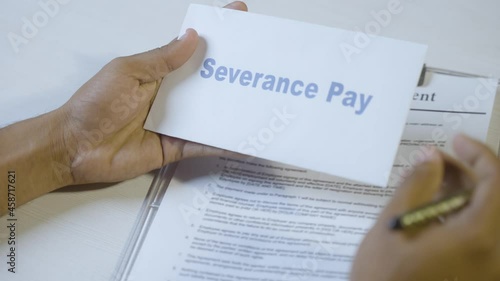POV shot of employee checking severance pay notice and signing on termination agreement or contract - concept of job loss during coronavirus covid-19 pandemic