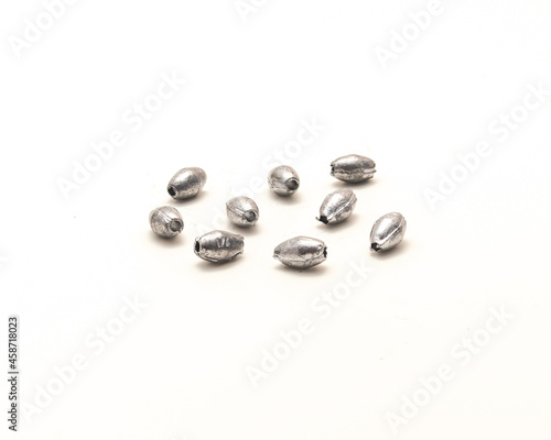 Pile of silver egg sinkers fishing tackle for Carolina rigging casting isolated on white