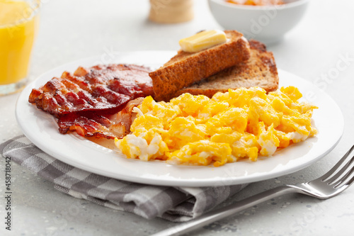 traditional scrambled egg breakfast with bacon and toast