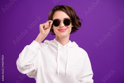 Photo of young smiling beautiful confident woman wear white sweatshirt sunglass isolated on violet color background