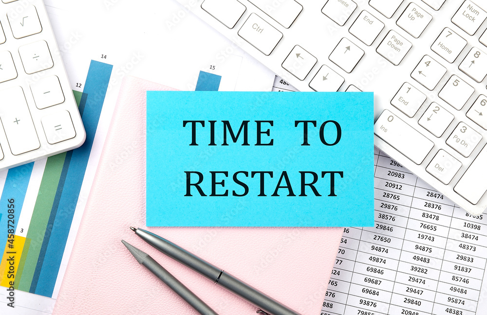 Obraz premium TIME TO RESTART text on blue sticker on chart with calculator and keyboard,Business