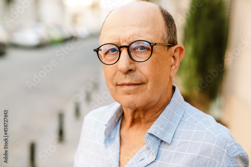 Smiling senior man in glasses looking at camera © Drobot Dean