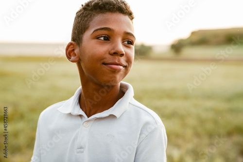 Black boy wearing white shirt smiling and looking aside
