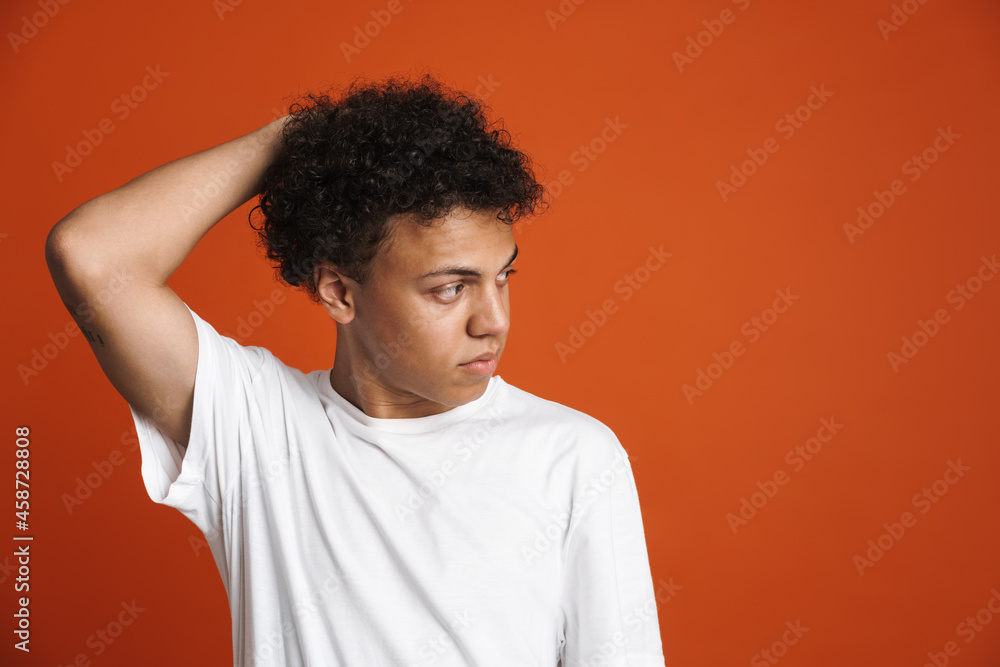 Young black man in t-shirt posing while looking aside Young black man in t-shirt posing while looking aside