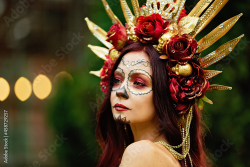 Young woman with painted skull on her face for Mexico's Day of the Dead. portrait of Calavera Catrina in red dress. Sugar skull makeup. Dia de los muertos. Day of The Dead. Halloween