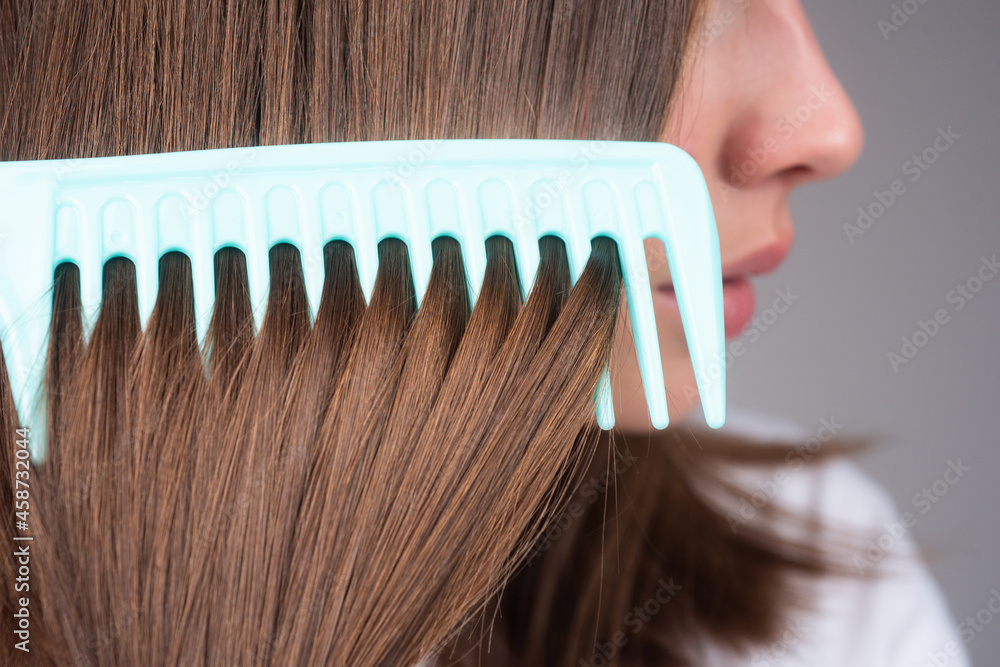 Obraz premium Close up hair, woman hairdresser with comb brushing hair.