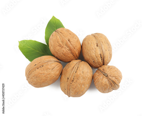 Whole walnuts in shell and leaves on white background, top view