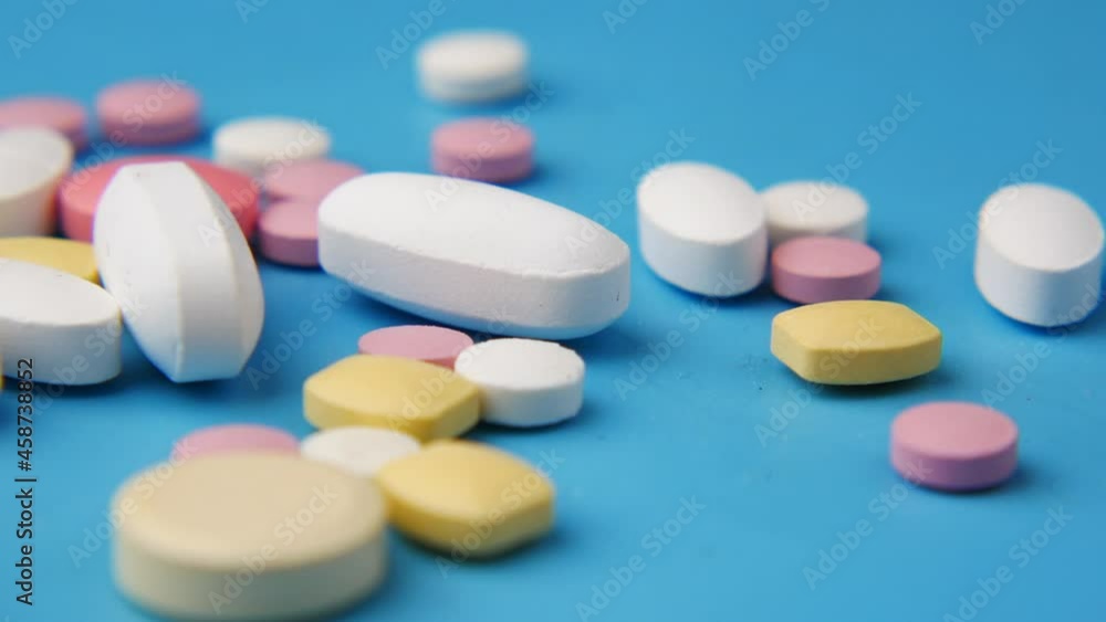Close up of many colorful pills and capsules on blue Close up of many colorful pills and capsules on blue