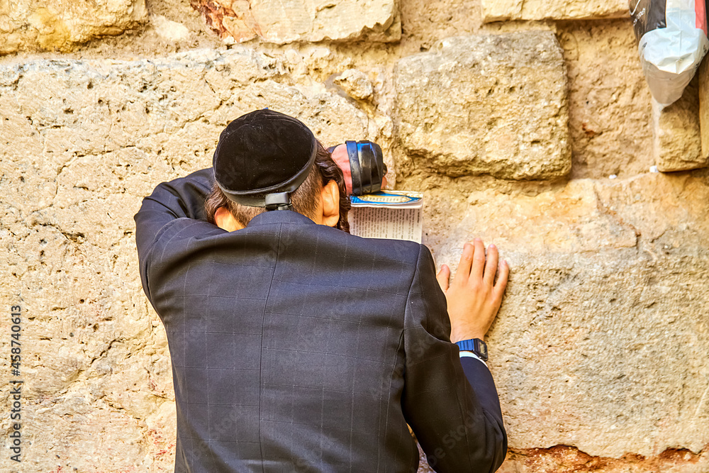 Orthodox Jewish man praying near the small Western-Wailing Wall, the holiest place in Judaism; Jerusalem Israel