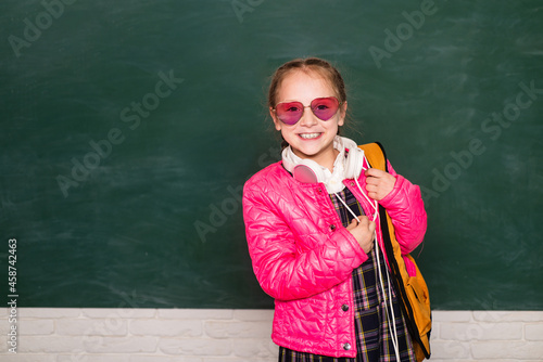 Funny school teen wearing eyeglasses backpack, child studio portrait. Education concept. Teenager younf school girl with backpack.