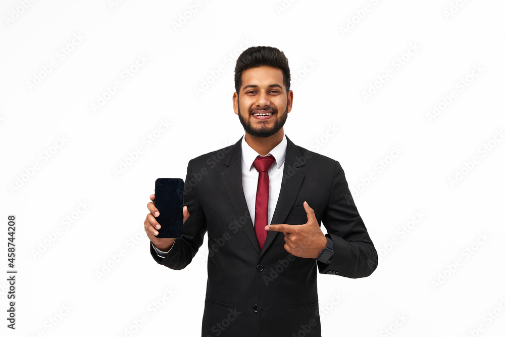 Portrait of young indian manager using and pointimg his phone on white isolated background, copy space for texting Portrait of young indian manager using and pointimg his phone on white isolated background, copy space for texting