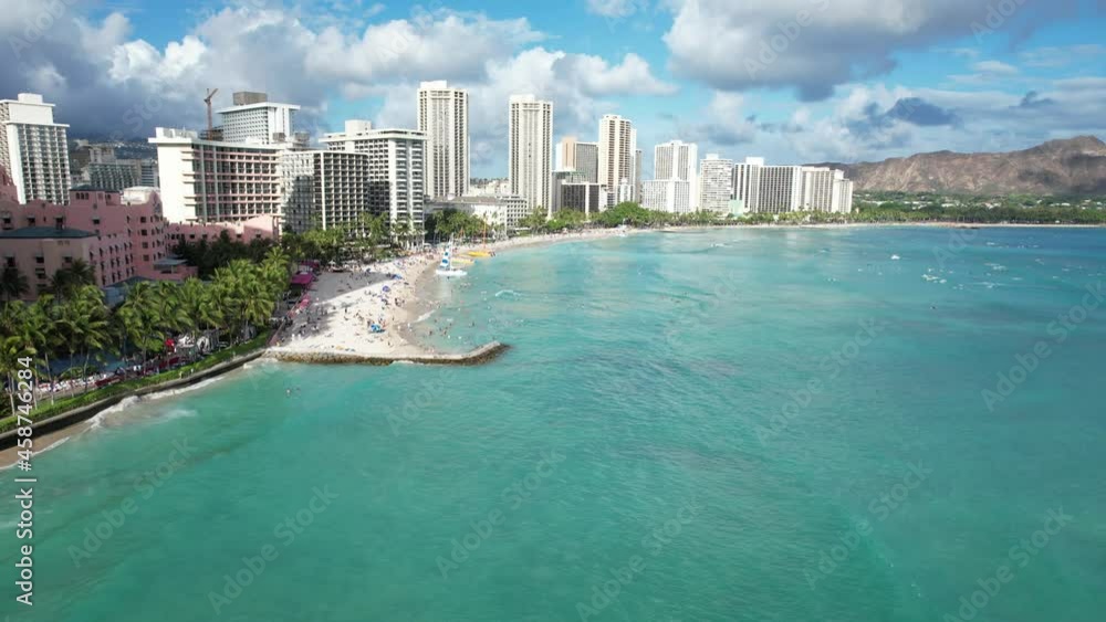 A drone glides down a tropical beach revealing the ocean front luxury hotels and families on vacation. A drone glides down a tropical beach revealing the ocean front luxury hotels and families on vacation.