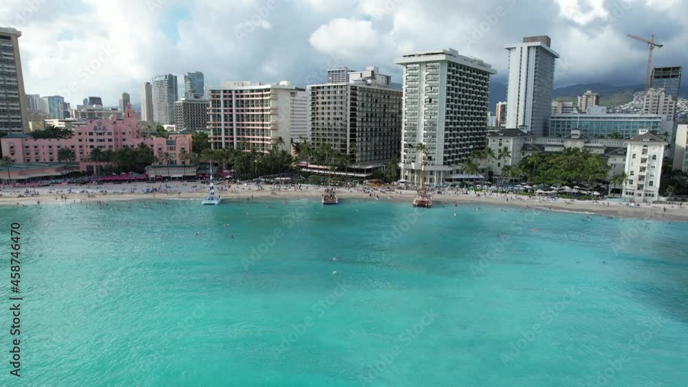 A drone starts out in the ocean over the water and glides towards water front luxury hotels. A drone starts out in the ocean over the water and glides towards water front luxury hotels.