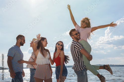 Group of friends having fun near river at summer party © New Africa