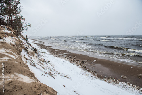 Baltic Sea wild beach is snowy in winter and there are big waves photo