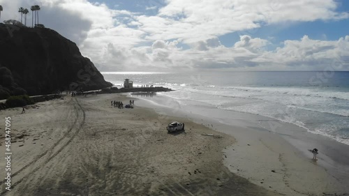 A drone flies around a lifeguard truck at the beach as the lifeguard keeps beach goes safe.