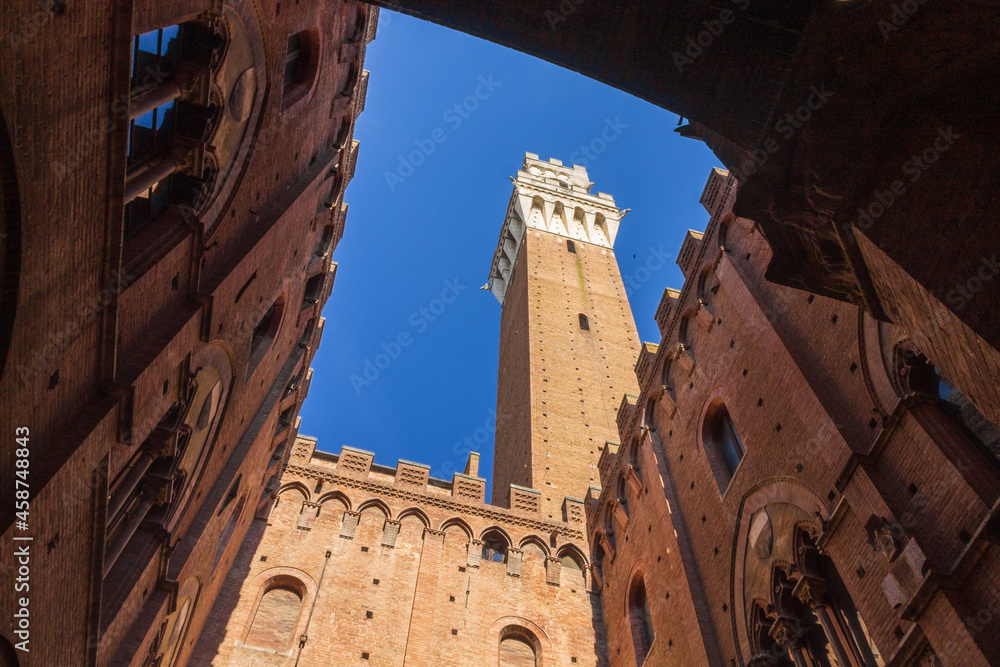 Lowa angle view of Torre del Mangia (Mangia tower) from the chapel, in Siena, Tuscany, Italy. Copy space