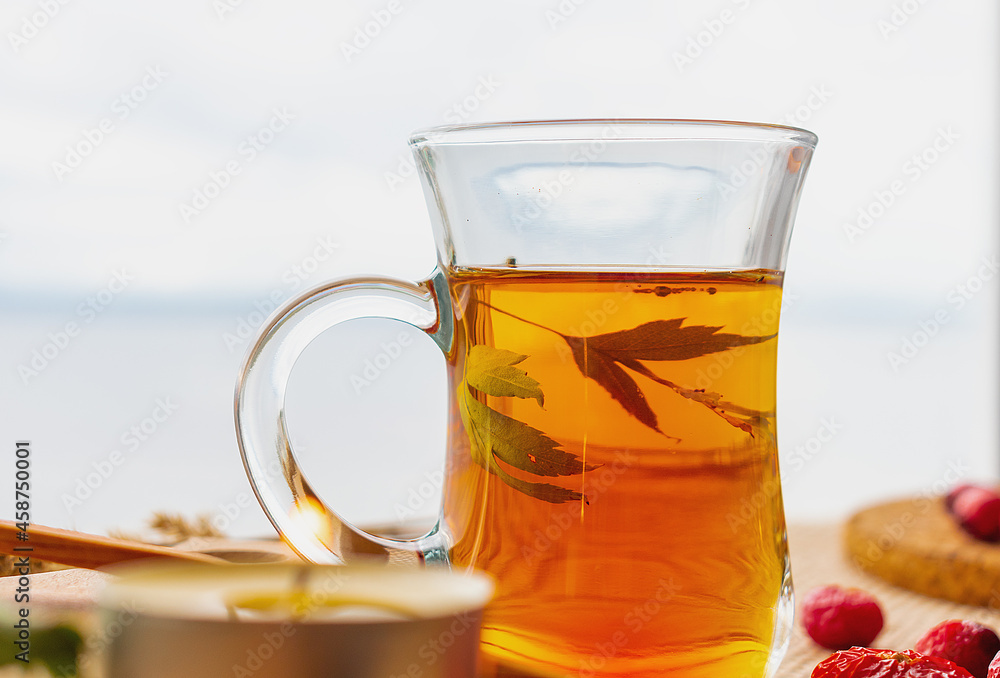 Black tea and rose hips on the background of a cloudy sky Black tea and rose hips on the background of a cloudy sky