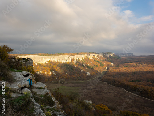 Smiling girl looking at the camera. Beautiful views of mountain on a sunny autumn day. The cave city of Eski-Kermen in the Bakhchysarai district, Crimea © Olivia