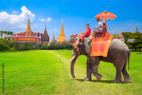 Tourists on an ride elephant dressing tradition at the Buddhist temple of Wat Phra Kaeo at the Grand Palace in Bangkok,Thailand © thanapun