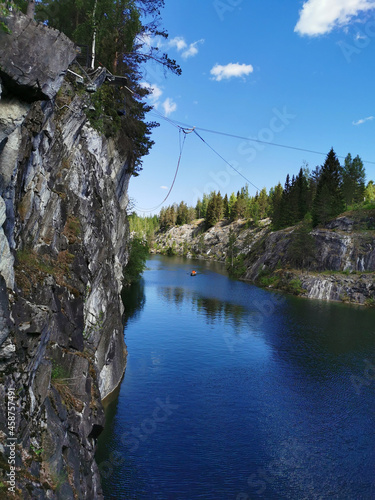 View of the rocks and the emerald water of the Marble Canyon in the Ruskeala Mountain Park  which reflects the sky and trees on a sunny summer day.