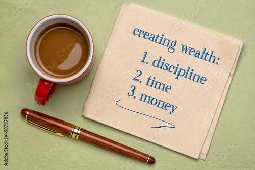 creating wealth - discipline, time and money, handwriting on a napkin with a cup of coffee, investing, retirement and financial concept
