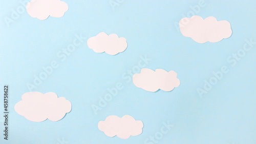 Stop motion animation. Cartoon. Paper white clouds made of paper float across the blue sky made of paper. Top view.