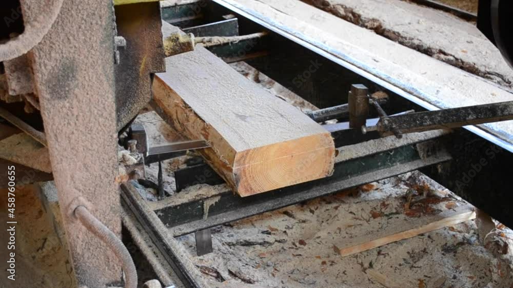 Sawmill. Process of machining logs in sawmill machine saws the tree trunk Sawmill. Process of machining logs in sawmill machine saws the tree trunk