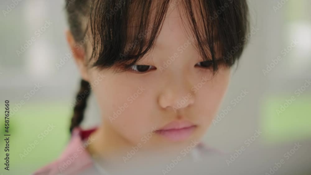 A close-up view of a concentrated asian girl study drawing on easel in the modern art school A close-up view of a concentrated asian girl study drawing on easel in the modern art school
