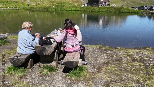 Happy family picknicking along a beautiful mountain lake. photo