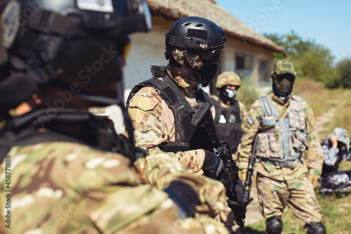 Group of airsoft players in military uniform. photo