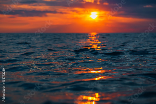 Cloudy sunset and surface of ocean. © artifirsov
