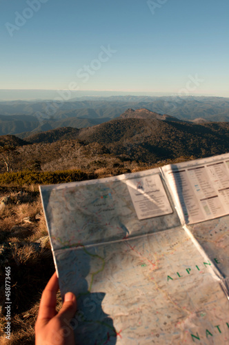 A map being held with mountain ranges in the background. photo