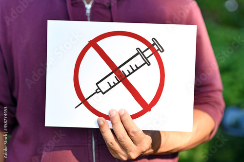 Anti vaccine demonstration sign with syringe drawing in red crossed out circle photo