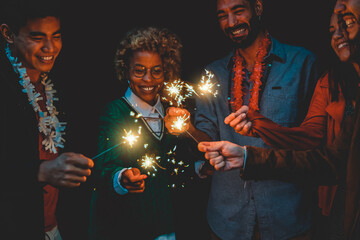 Happy diverse friends celebrating with sparklers on new year eve - Soft focus on african woman face