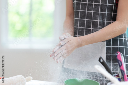 closeup woman hands clapping and sprinkling white flour for making a bread
