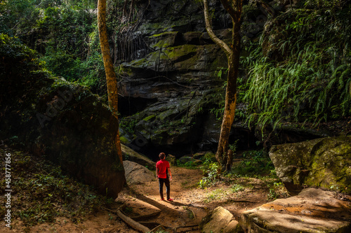 Wallpaper Mural Tourists stand in front of a large rock on the tropical forest at Tat Fa Waterfall, the best waterfall within Phu Wiang National Park, Khon Kaen, Thailand. Torontodigital.ca