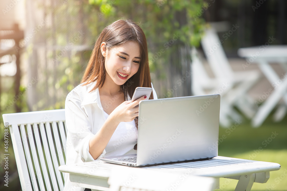 Young Asian woman using laptop computer and tablet PC to working in the modern co working space Young Asian woman using laptop computer and tablet PC to working in the modern co working space