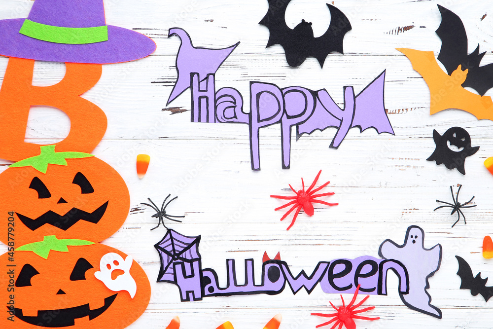 Text Happy Halloween with paper pumpkins, ghosts, bats, spiders and candies on wooden background