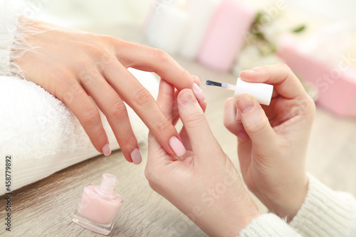 Manicurist making manicure for client in salon