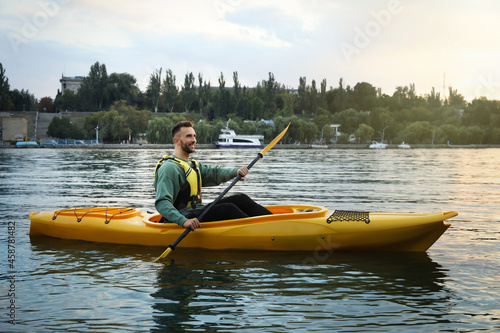Handsome man kayaking in river. Summer activity