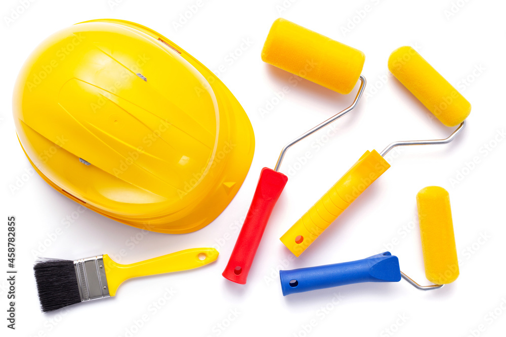 Paint roller and hard hat isolated at white background. Construction helmet with tool Paint roller and hard hat isolated at white background. Construction helmet with tool