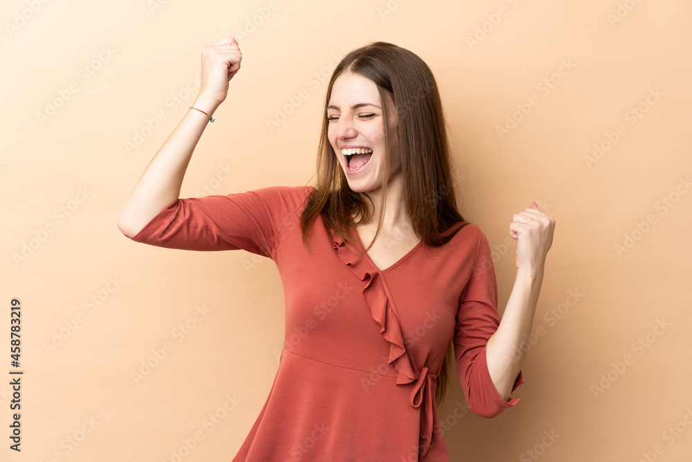 Young caucasian woman isolated on beige background celebrating a victory Young caucasian woman isolated on beige background celebrating a victory