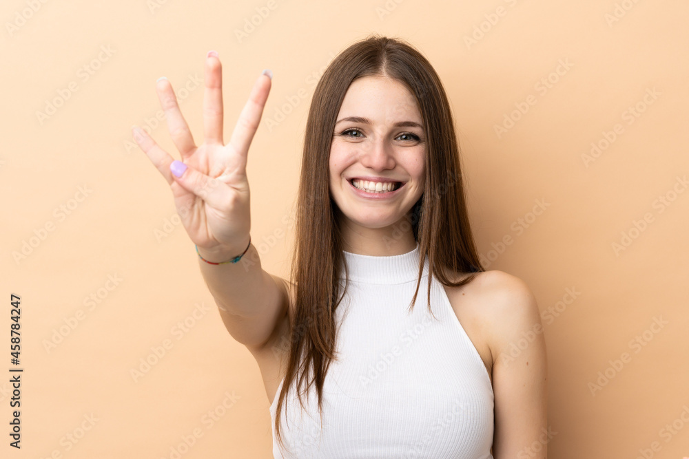 Young caucasian woman isolated on beige background happy and counting four with fingers Young caucasian woman isolated on beige background happy and counting four with fingers