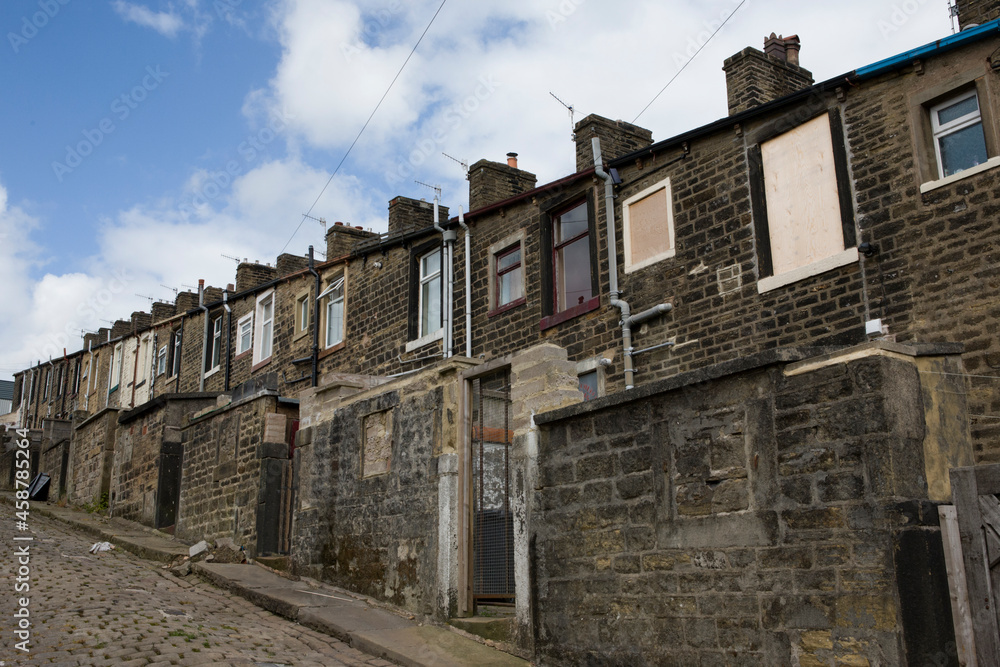 A steep terrace of traditional 19th century millworkers' cottages, seen from the back lane between Basil Street and Walton Street: Colne, Lancashire, UK