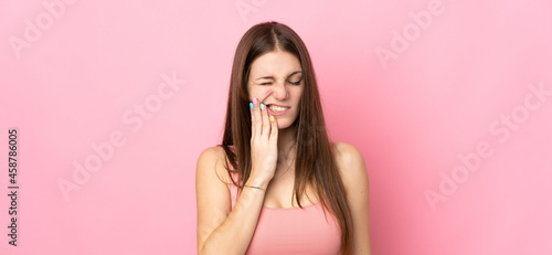 Young caucasian woman isolated on pink background with toothache