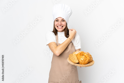 Young woman in chef uniform isolated on white background celebrating a victory