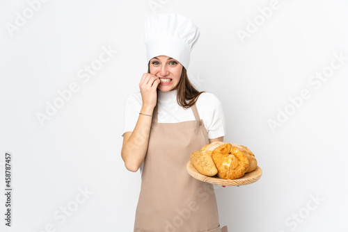 Young woman in chef uniform isolated on white background nervous and scared